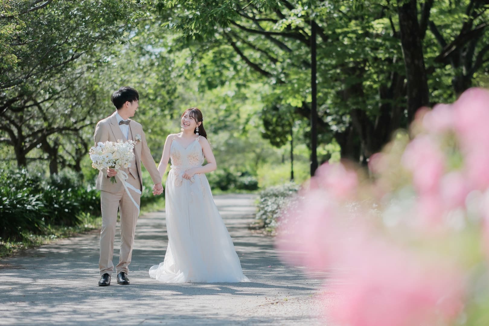 alt="庄内緑地公園で前撮りする自然な笑顔の新郎新婦"