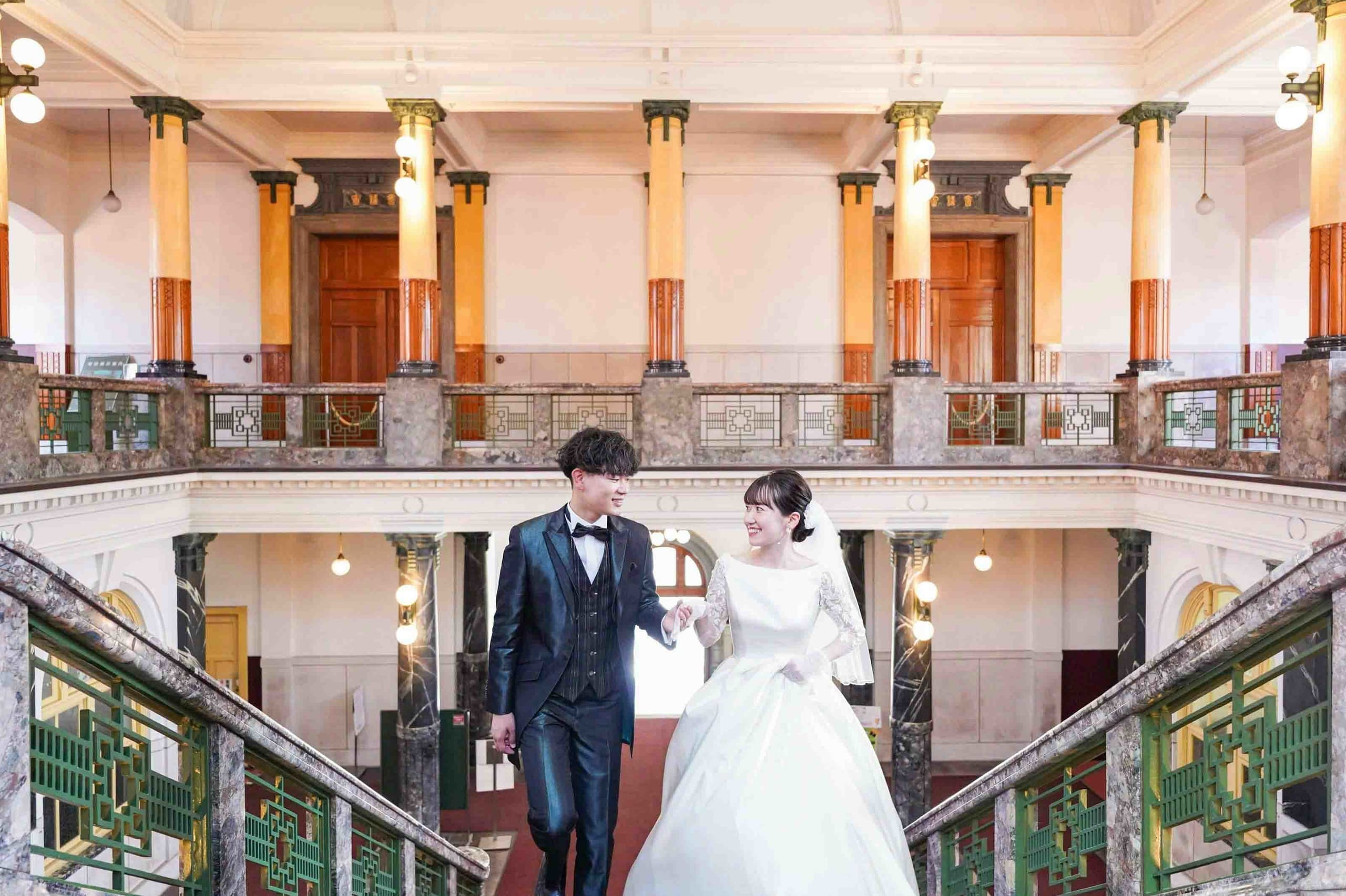 alt="市政資料館でドレス前撮りをする笑顔の新郎新婦"