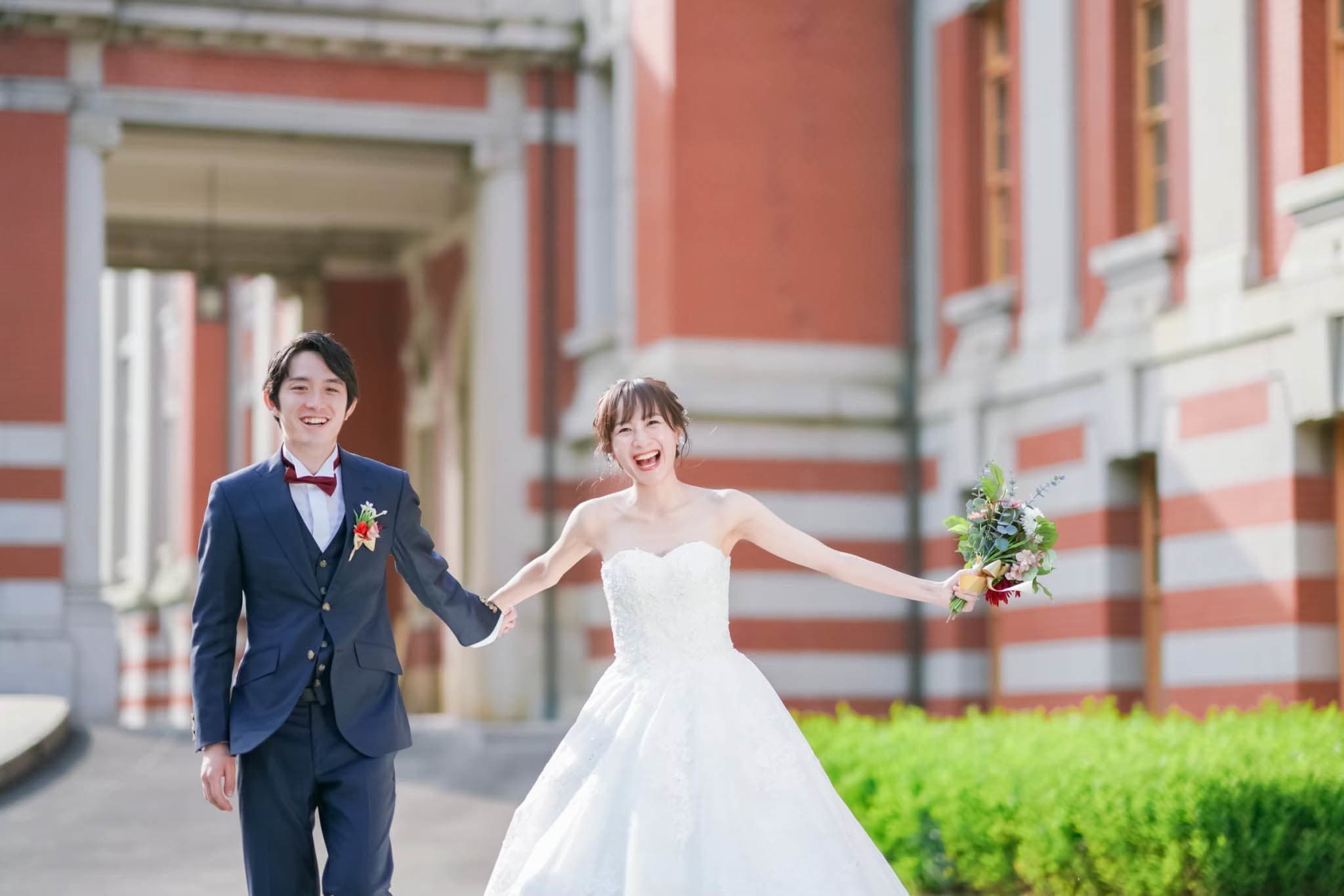 alt="市政資料館でドレス前撮りをする笑顔の新郎新婦"