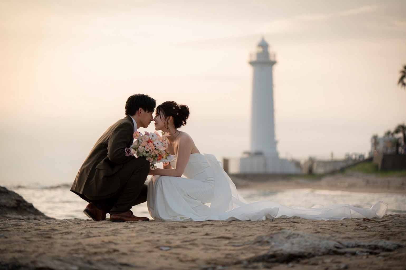 alt="野間灯台でビーチ前撮りをする笑顔の新郎新婦"