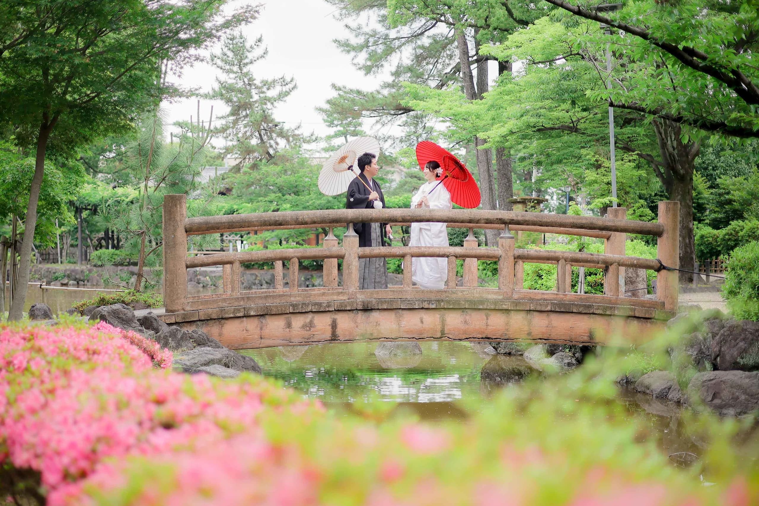 alt="中村公園で和装前撮りをする笑顔の新郎新婦"