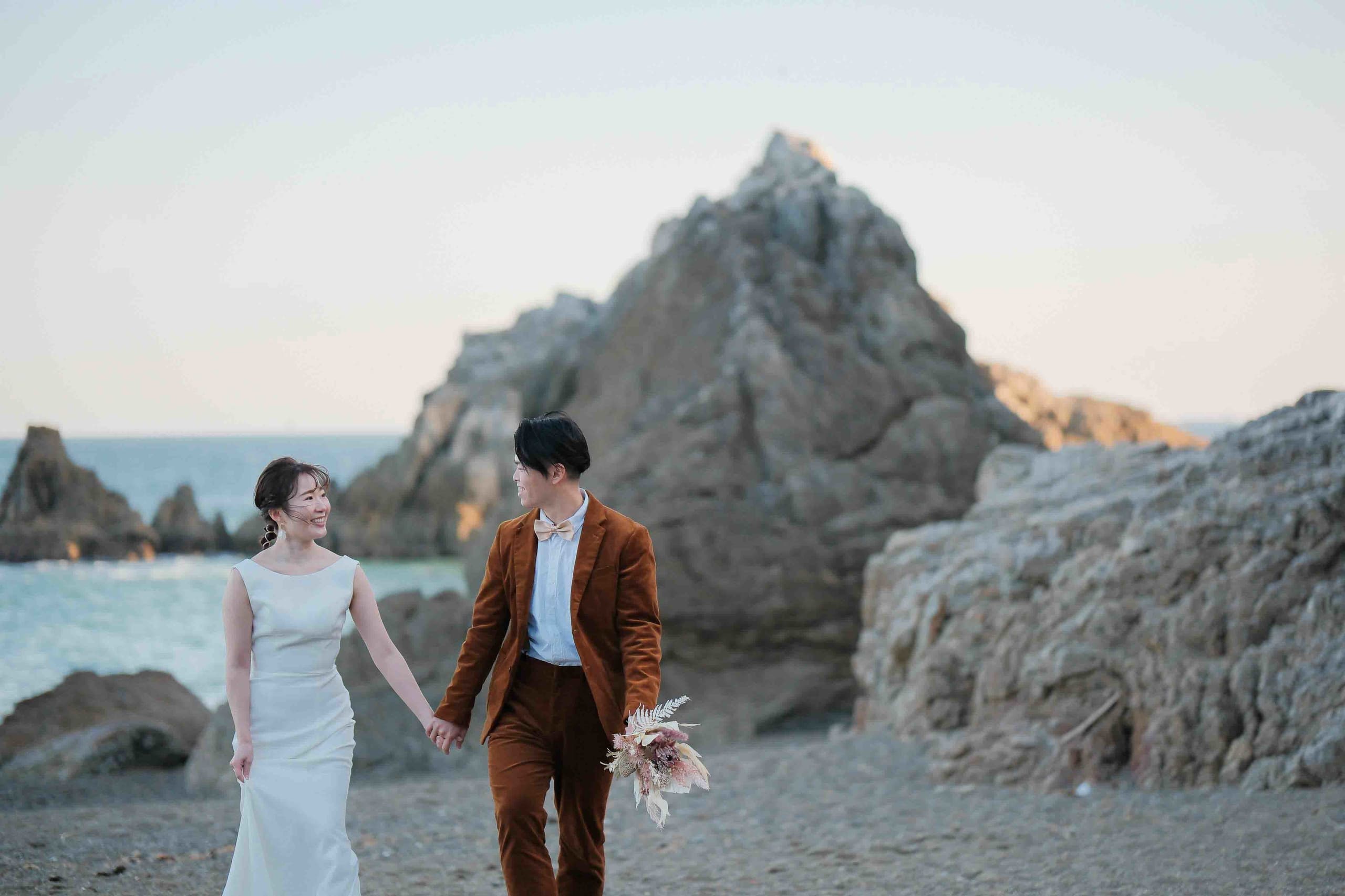 alt="伊良湖でビーチ前撮りする自然な笑顔の新郎新婦"