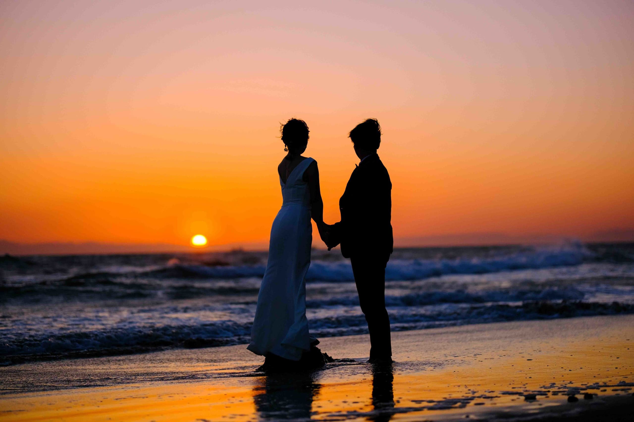 alt="伊良湖でビーチ前撮りする自然な笑顔の新郎新婦"