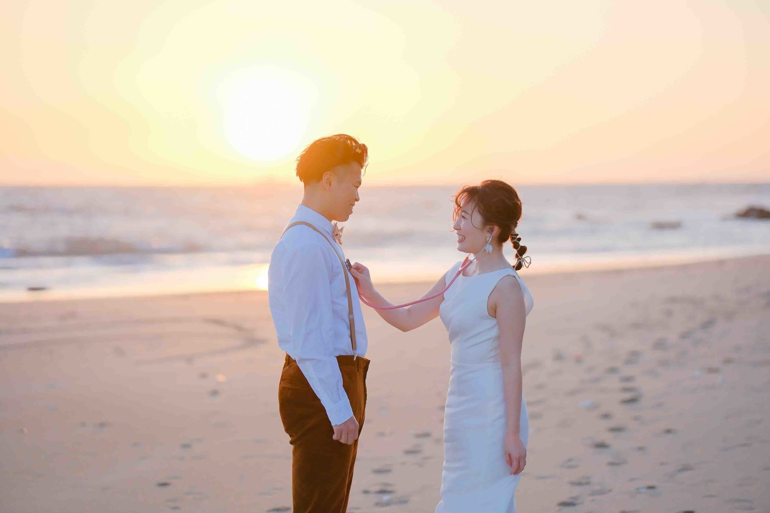 alt="伊良湖でビーチ前撮りする自然な笑顔の新郎新婦"