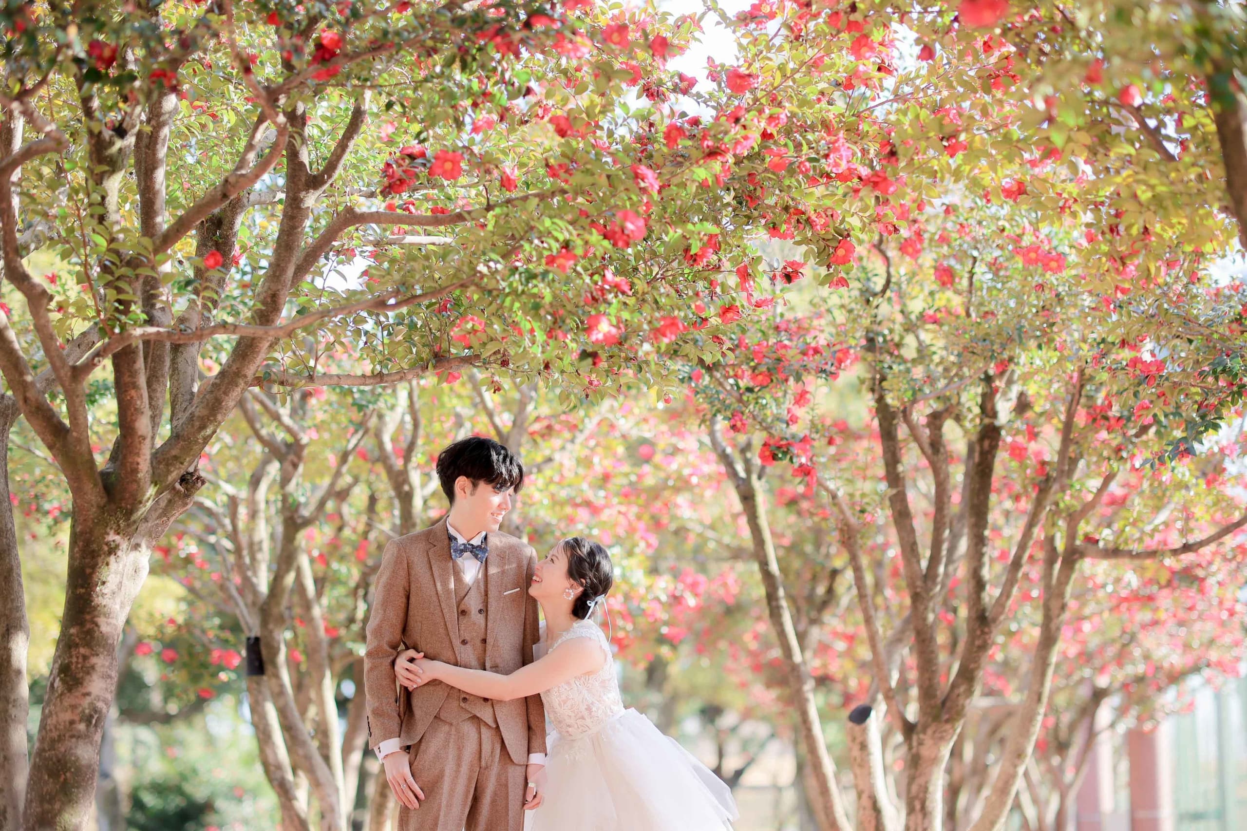 alt="庄内緑地公園でドレス前撮りをする笑顔の新郎新婦"