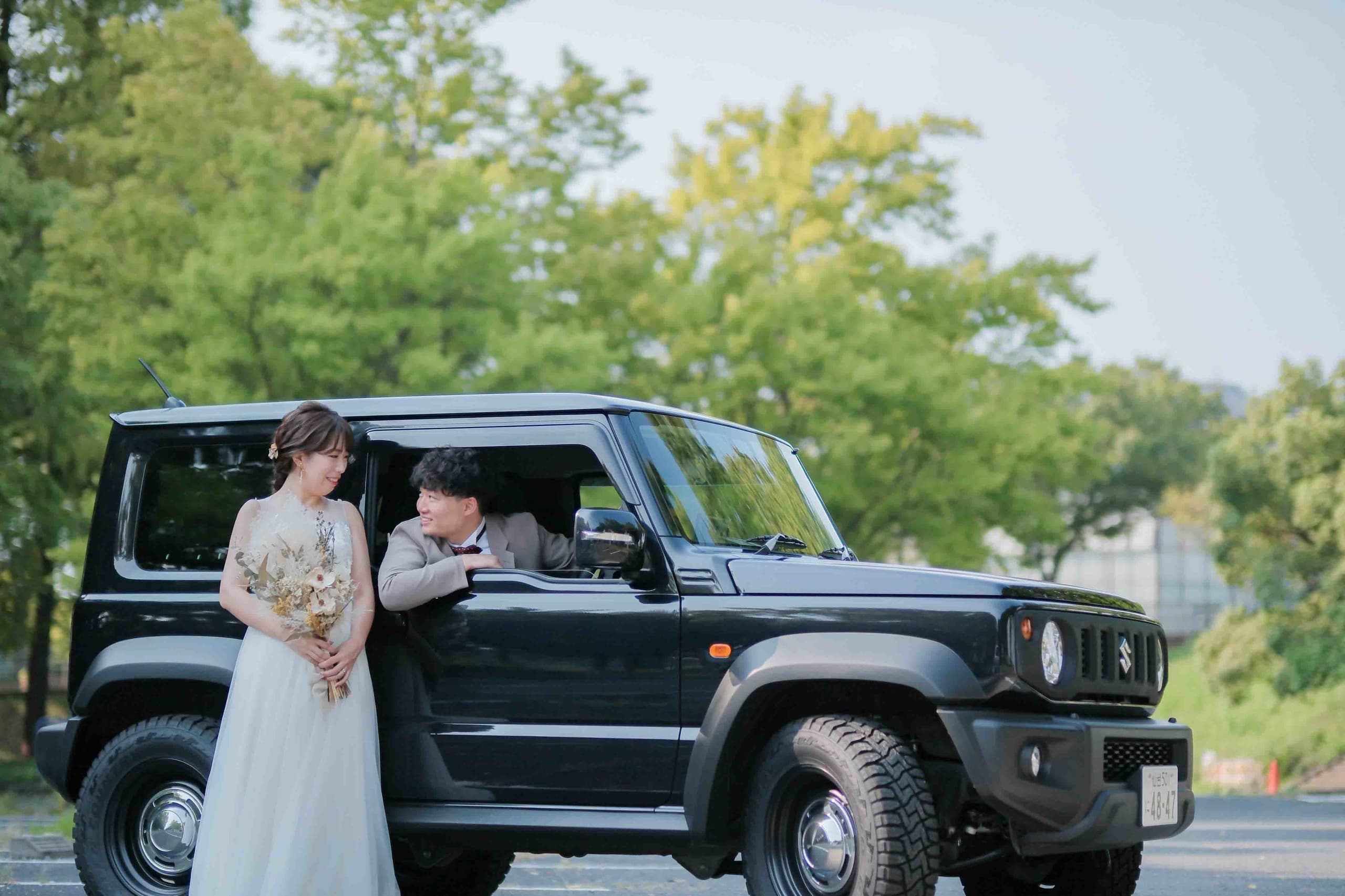 alt="庄内緑地公園でドレス前撮りをする笑顔の新郎新婦"