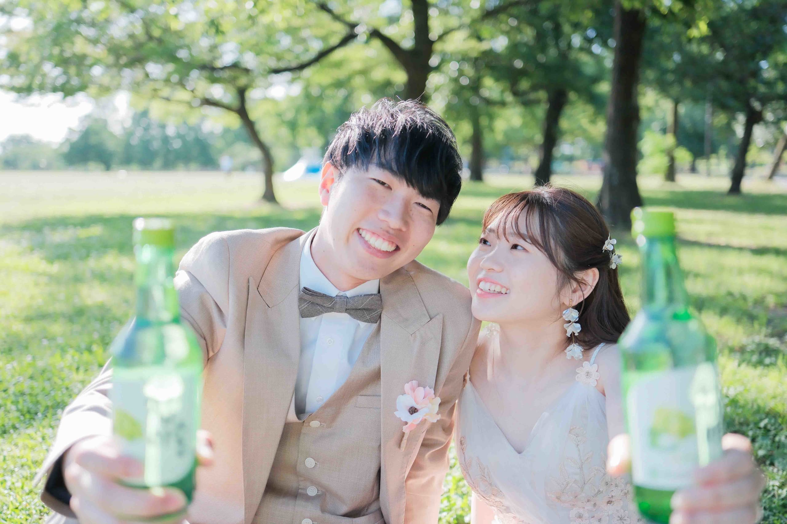 alt="庄内緑地公園でドレス前撮りをする笑顔の新郎新婦"