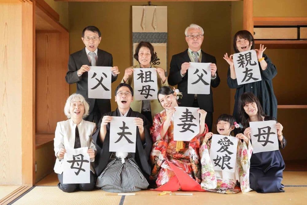 東山荘前撮りで家族と写真を撮る新郎新婦